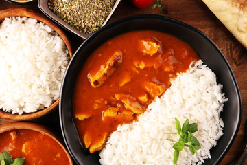 Chicken tikka masala spicy curry meat food in pot with rice and naan bread. indian food on table