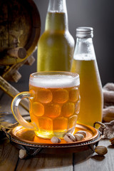 Light beer in a glass on a table in composition with accessories on an old background