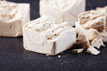 Dry yeast crumbled and yeast block for baking on background