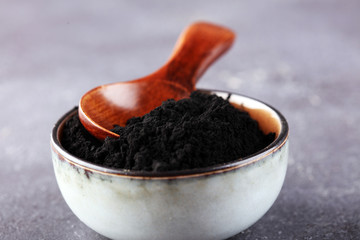 Activated charcoal powder. Black charcoal powder on table