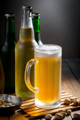 Light beer in a glass on a table in composition with accessories on an old background