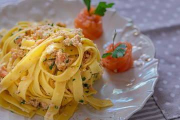 A plate with fettuccine pasta with salmon.
