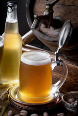 Light beer in a glass on a table in composition with accessories on an old background