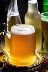 Light frothing beer in a glass, on an old background.