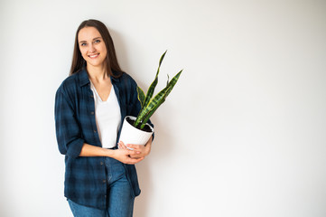 Young woman holds a flower pot in her hands