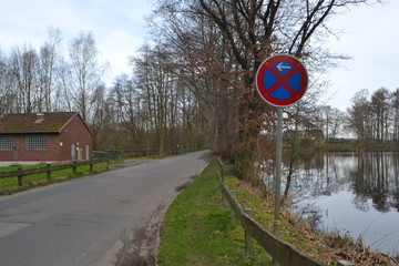 Stra&szlig;e mit Schild am See