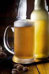 Light frothing beer in a glass, on an old background.
