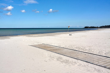 Wooden boardwalk on a sandy beach.