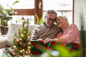 Senior couple sitting in the living room together during Christmas