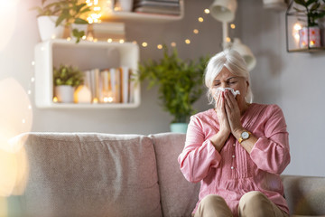 Senior woman blowing her nose 