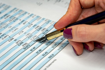 Financial income statement with woman hand writing on paper with numbers