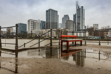 Spiegelung Bank in Regenpfütze vor Frankfurter Skyline 