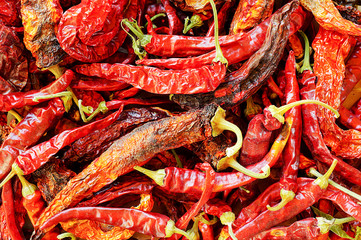 Hot chili peppers in dried form with a bright multicolored color. Top view, background, close- up. Wasteless production. Ugly..