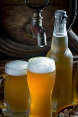 Light beer in a glass on a table in composition with accessories on an old background