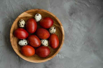Easter concept. Natural Easter eggs in a wooden bowl cooked in onion peels on a dark stone background. Horizontal orientation. Selective focus. Top view. Copy space.