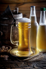Light beer in a glass on a table in composition with accessories on an old background
