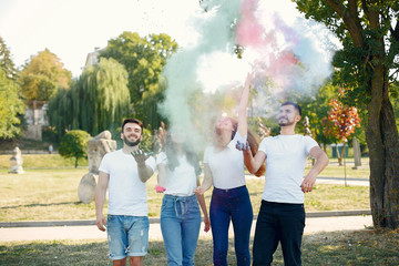 Friends with a holi paints. People in a summer park. Students have fun.