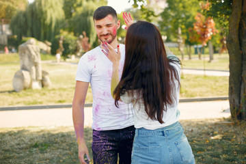 Fototapeta premium Friends with a holi paints. People in a summer park. Students have fun.