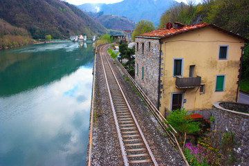 Fototapeta na wymiar The Tuscan Serchio river in Borgo a Mozzano and the reflection of the sky on a cloudy day
