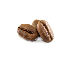 Three roasted coffee beans on a white background. Close-up.