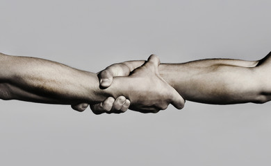 Friendly handshake, friends greeting, teamwork, friendship. Close-up. Rescue, helping gesture or...