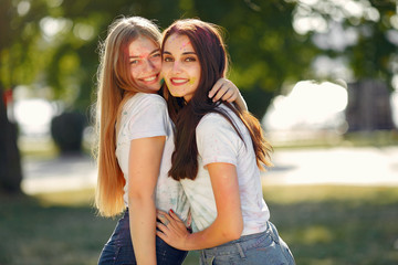 Fototapeta premium Friends with a holi paints. People in a summer park. Girls have fun.