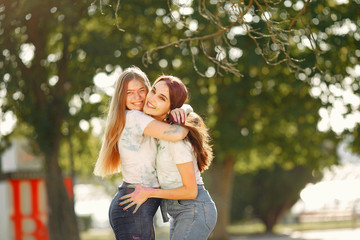 Fototapeta premium Friends with a holi paints. People in a summer park. Girls have fun.