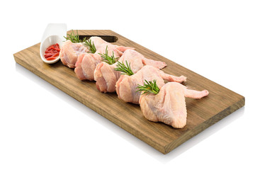Primal cut of raw chicken wings on a wooden cutting board. Isolated on white background.