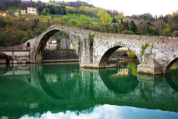 The suggestive and famous Ponte del Diavolo of Lucca built in bricks over a river in an ancient...