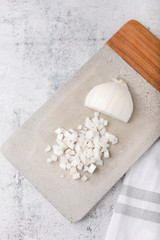 Chopped White Onions on Cement Cutting Board on Cement Countertop