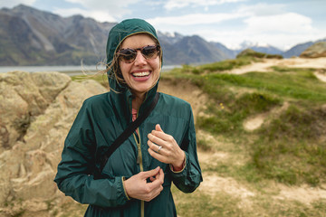 A young woman hiking in a windy valley in New Zealand, home to Mount Sunday