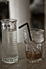 bottle of water and glass with straw on table