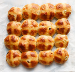 Fresh homemade hot cross buns on a wooden table, top view