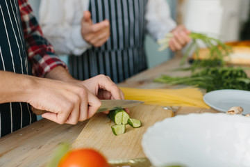 Son with his senior father cooking in the kitchen.