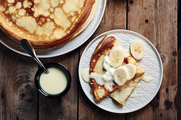 Thin pancakes, crepes with bananas and condensed milk.