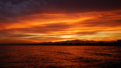 Fototapeta premium Sunset over some mountains with cloudy sky