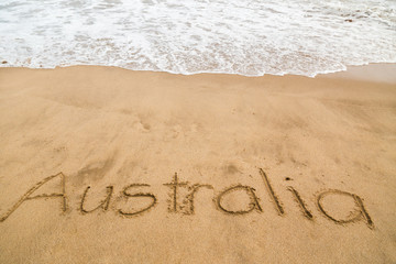 The word, Australia, handwritten on a sandy, golden surf beach in Victoria