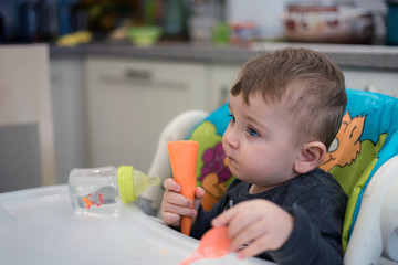 The child eats himself. Mother feeds the baby with a spoon. The emotions of a child. First independent feeding.
