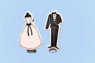 top view of decorative classic wedding dress and black groom tuxedo clips together isolated on purple surface with copy space, greeting concept