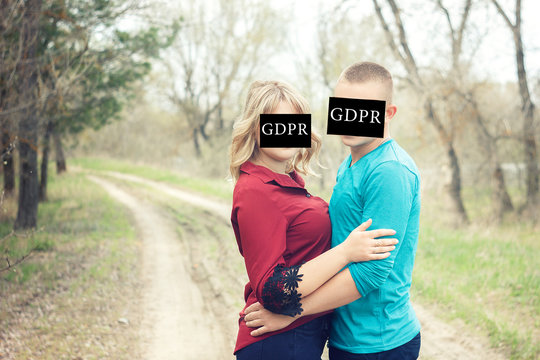 Couple embraces in nature with the inscription on the face of the GDPR (General data protection provisions) ban on photos of people on the street