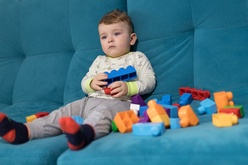 Obraz premium The emotions of a child. Joy and a smile on the baby's face. A boy in a shirt and tie on a toy horse, with a bouquet of flowers