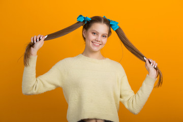 beautiful young woman with long hair on a yellow background