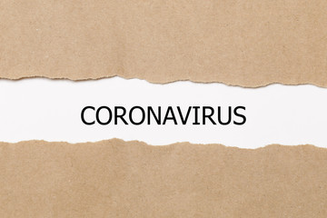 Fototapeta na wymiar The word CORONAVIRUS appearing behind torn paper