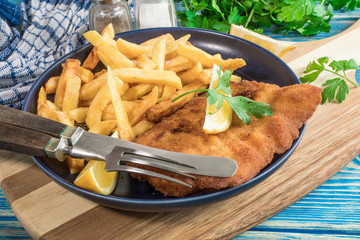 A piece of fried cod with fries on a plate.