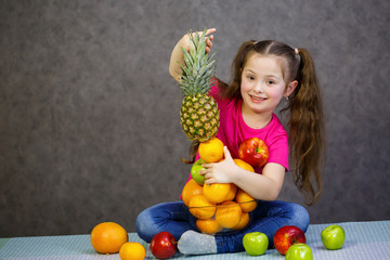 Fototapeta na wymiar A little girl six years old loves fruits very much. Vitamins and healthy eating.
