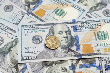Ten russian rubles coin lying on american usd dollar background, devaluation of national currency concept