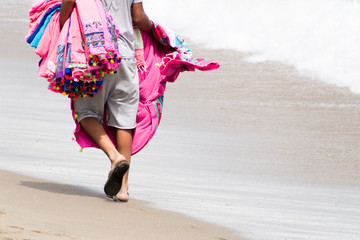man walking on beach with pink blankets