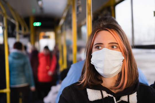 Young female adult commutes in a protective face mask. Coronavirus, COVID-19 spread prevention concept, responsible social behaviour of a citizen