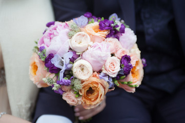 Delicate bouquet of pink and white flowers in the hands of the bride. Unusual wedding stylish bouquet with pink, orange, purple, white flowers, wedding dress, details