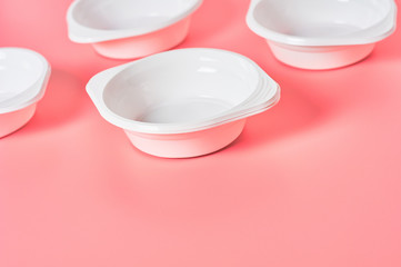 Disposable plastic bowls scattered on pink background. Concept of save environment, ecology, recreation on picnic, party and other events. Copy space